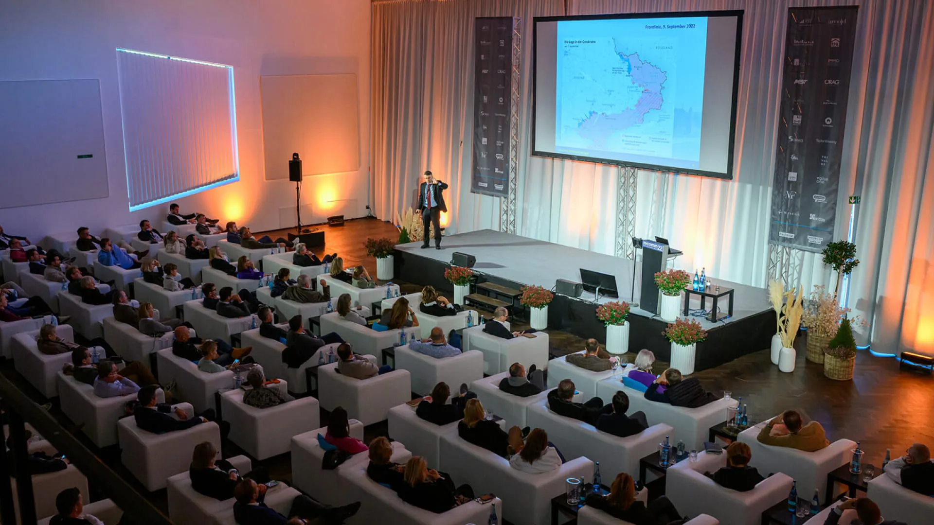 Konferenzpublikum in modernem Veranstaltungsort mit Präsentation