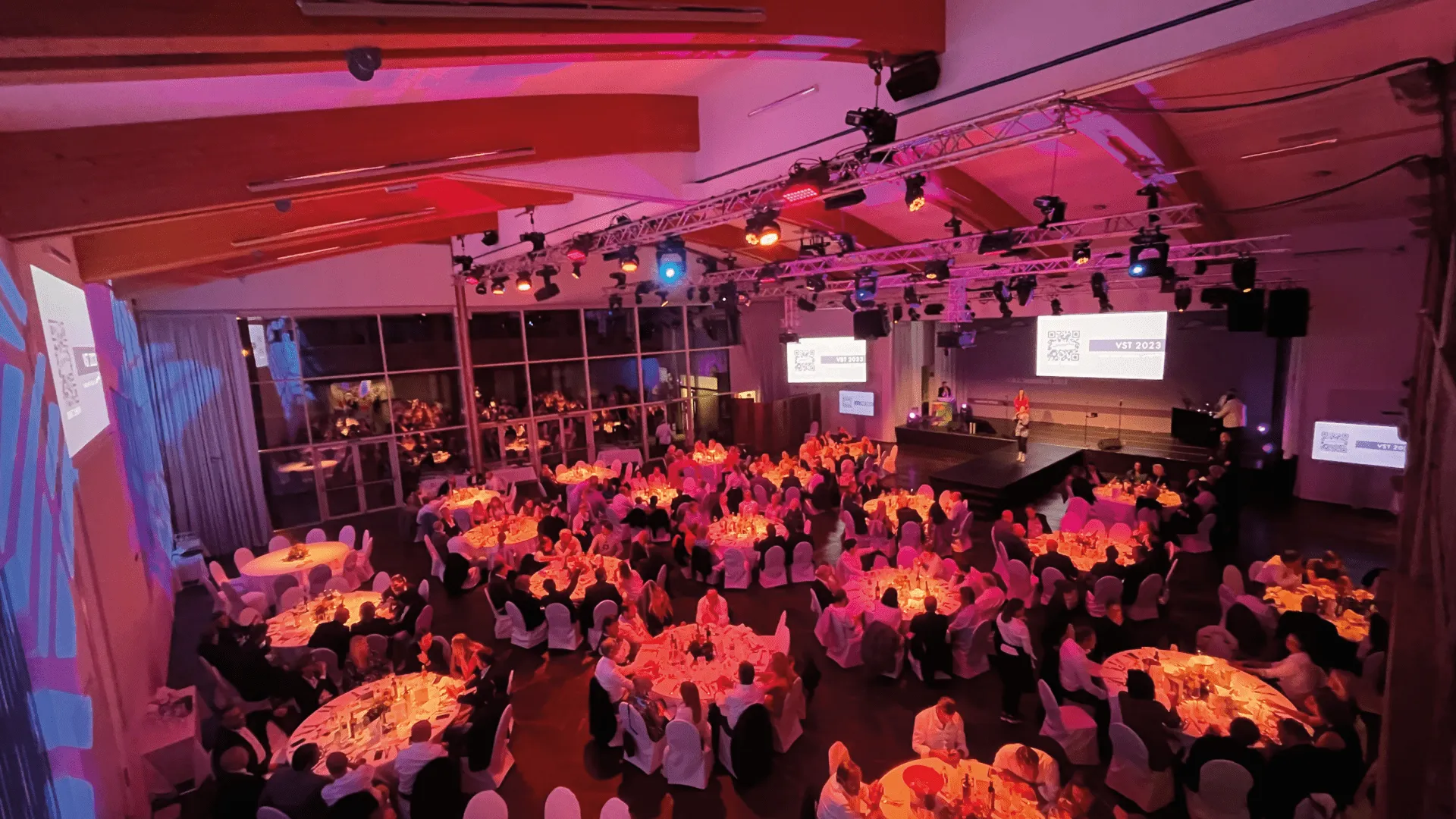 Eleganter Galaabend mit runden Tischen und Ambientebeleuchtung im Plenum Palladium.