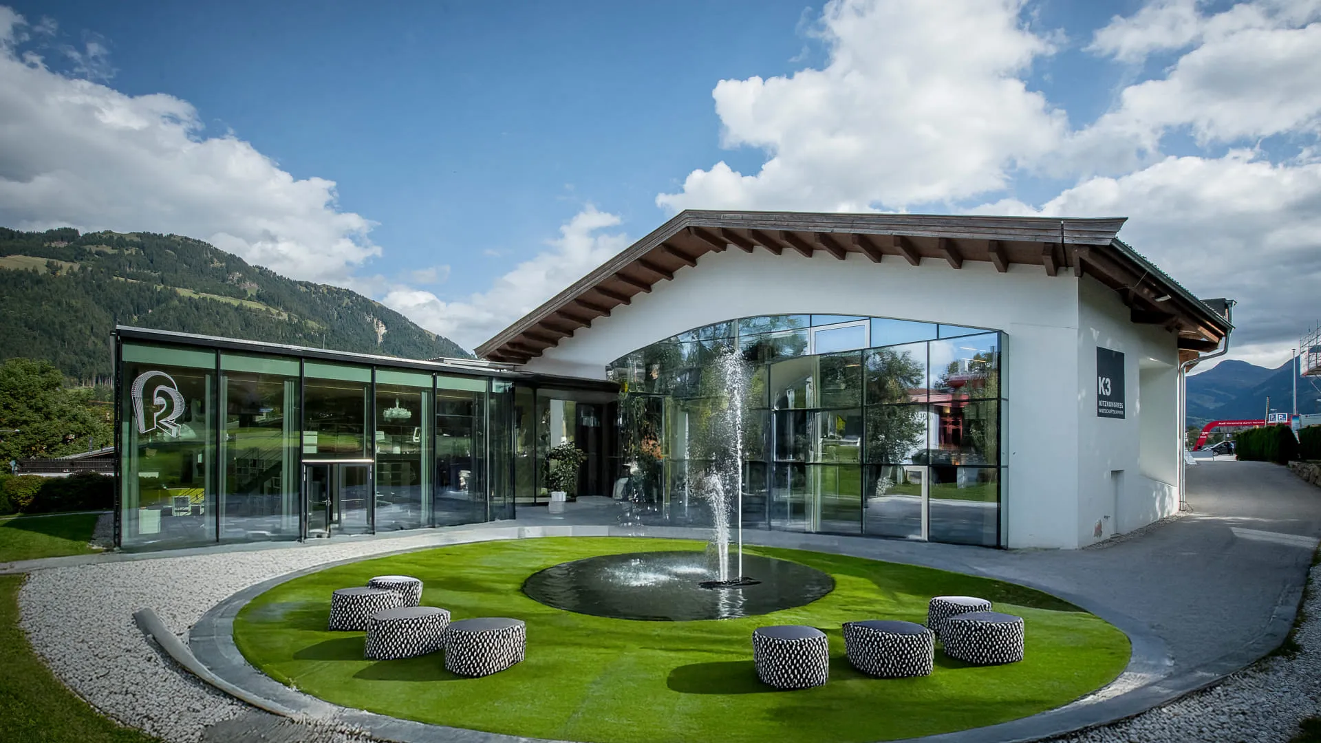 Modernes Gebäude mit Brunnen und Rasenfläche.