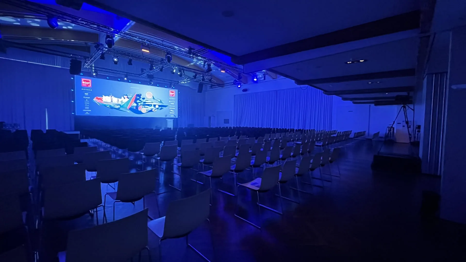 Leere Stuhlreihe in einem beleuchtetem Konferenzraum