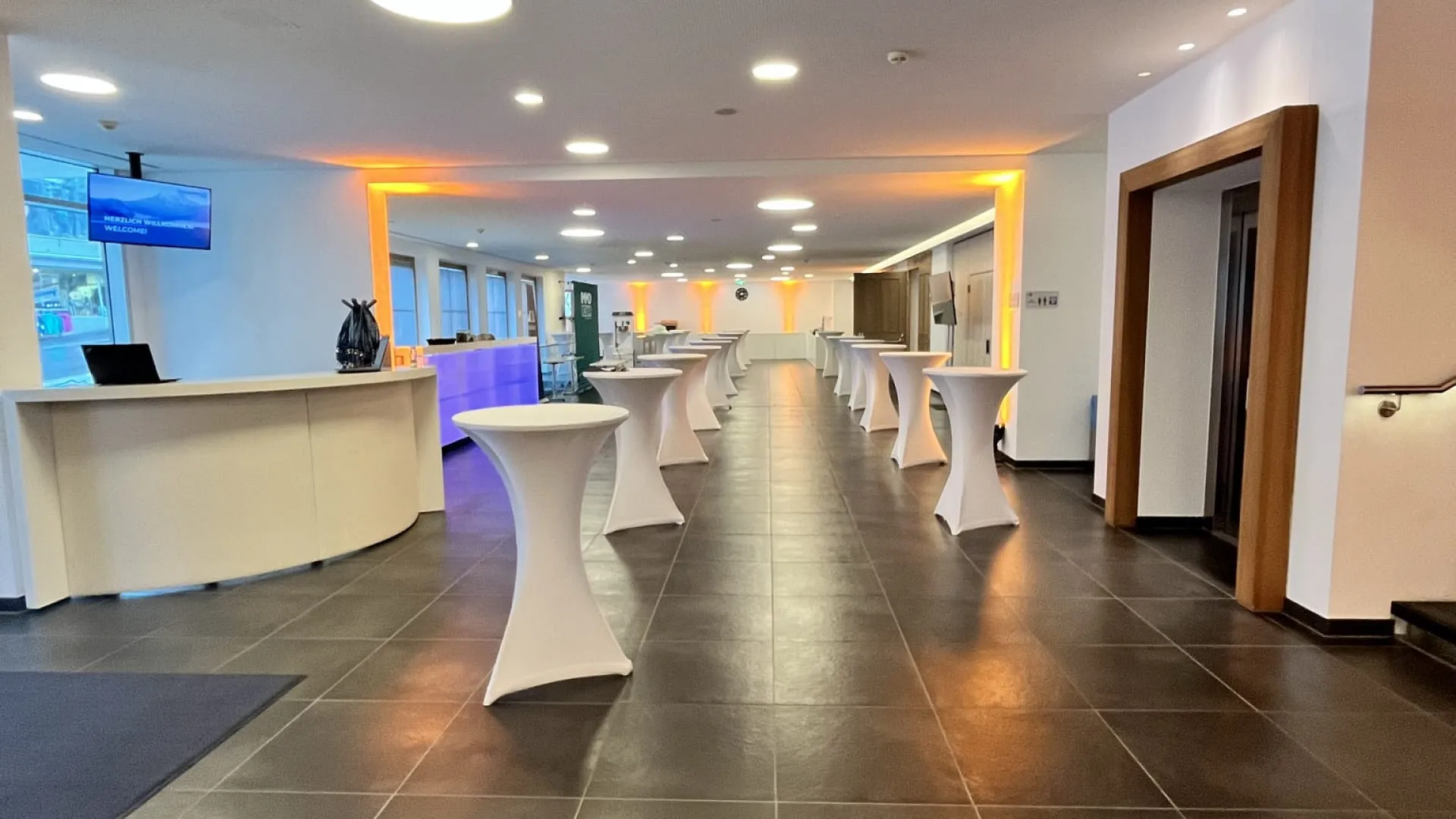 Modernes Veranstaltungsinterieur mit Tischen und eleganter Gestaltung