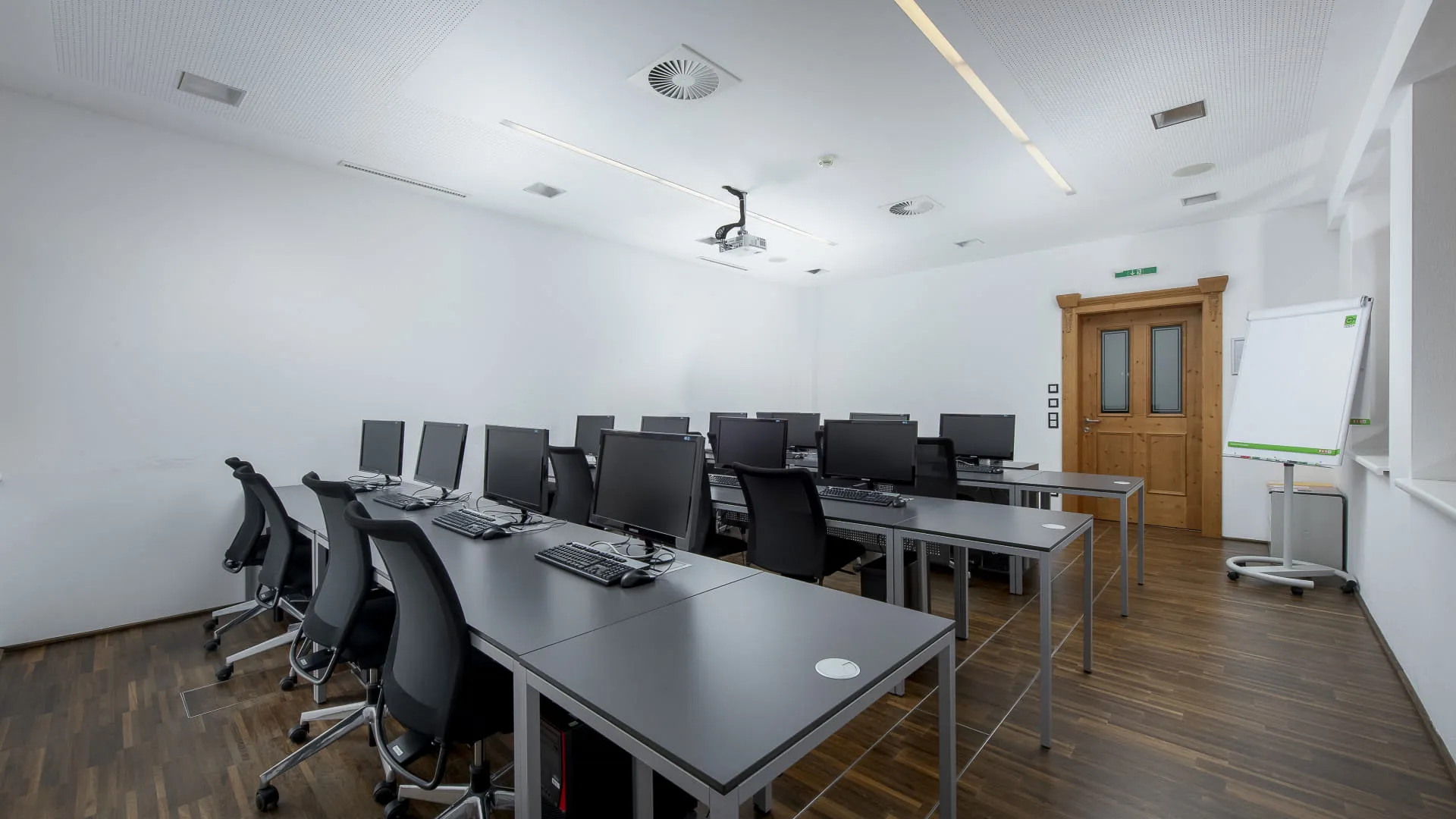 Moderne Schulungsräume mit Computertischen und Stühlen