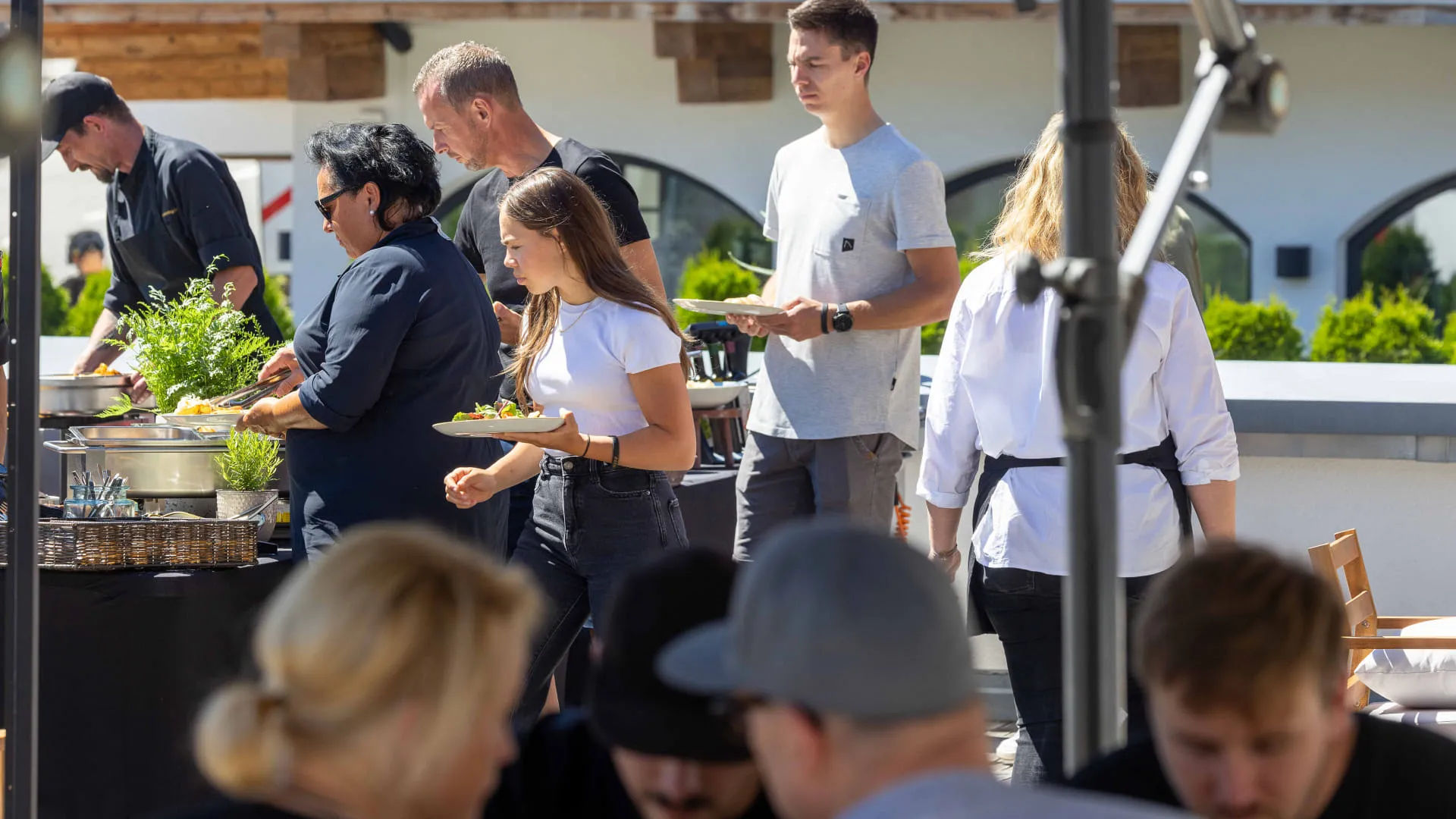 Menschen bei einem sonnigen Außen-Dinner-Event.