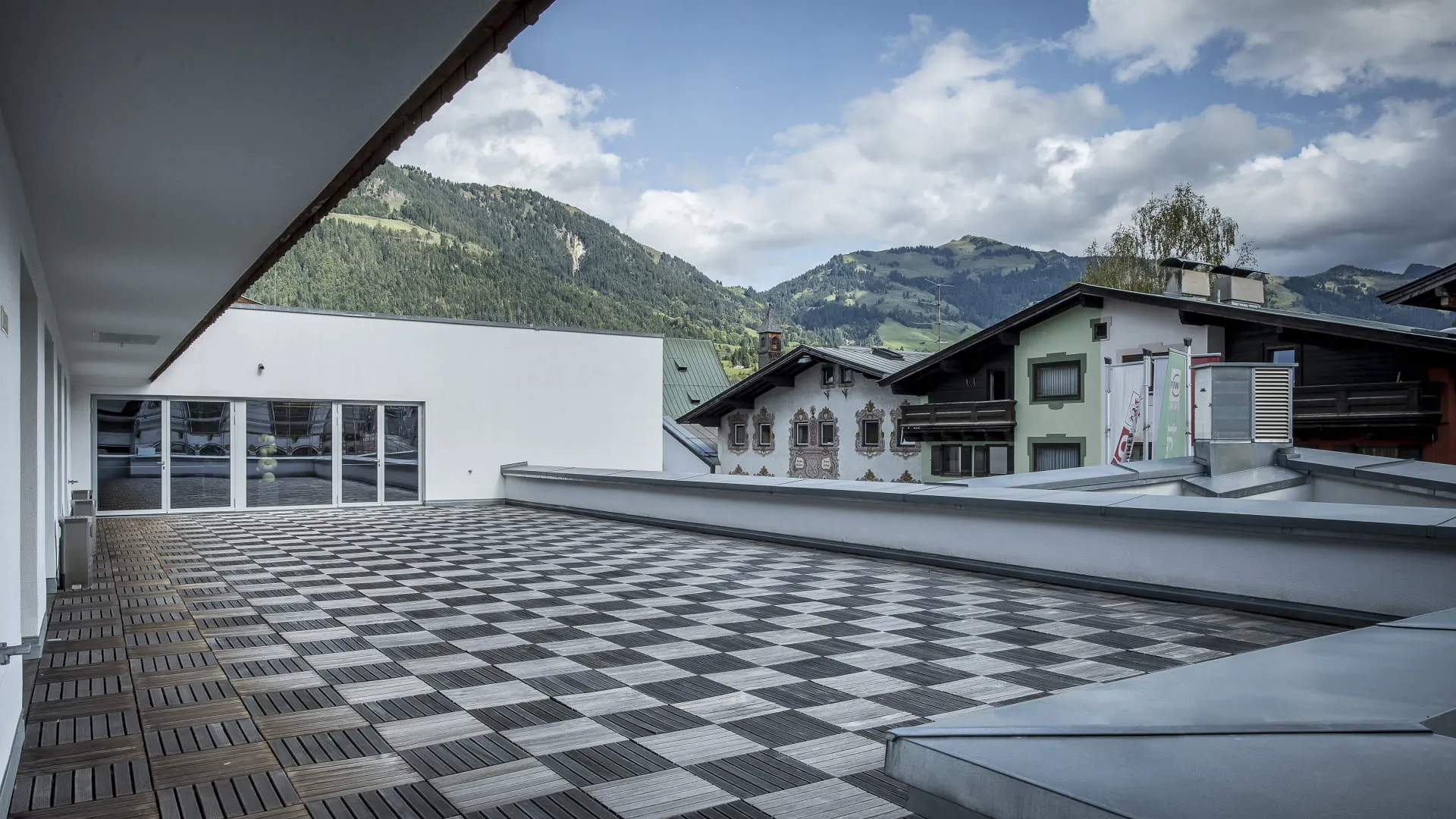 Blick auf eine Terrasse mit Fliesen und Berglandschaft.