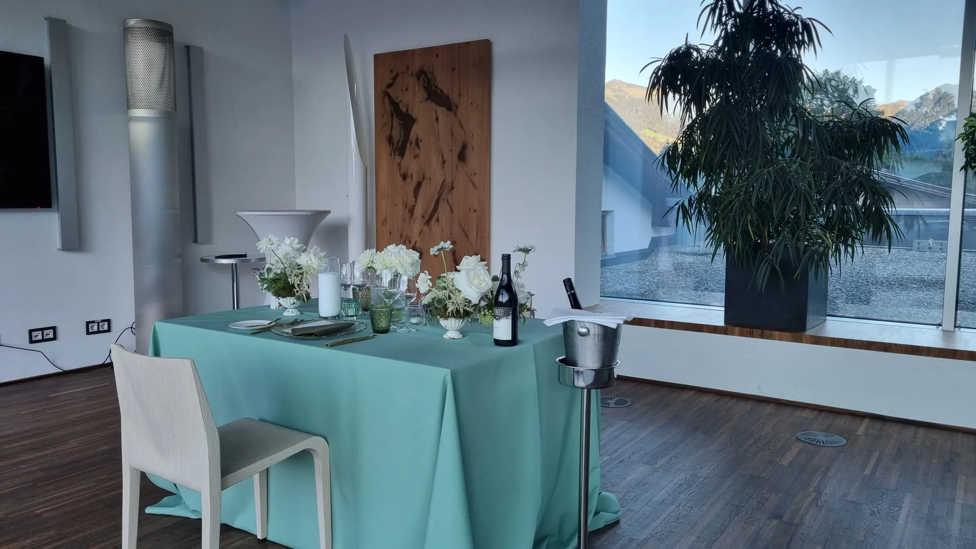 Esstisch mit grünem Tischdecken und Blumen drinnen