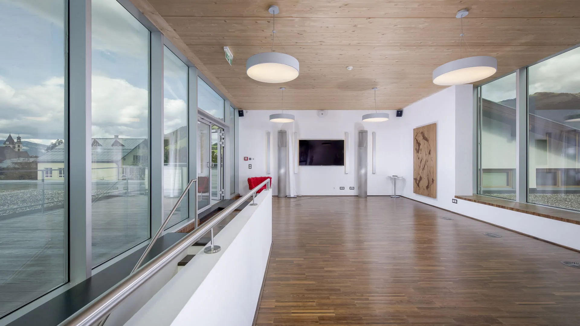 Moderne Lounge mit Holzboden und großen Fenstern