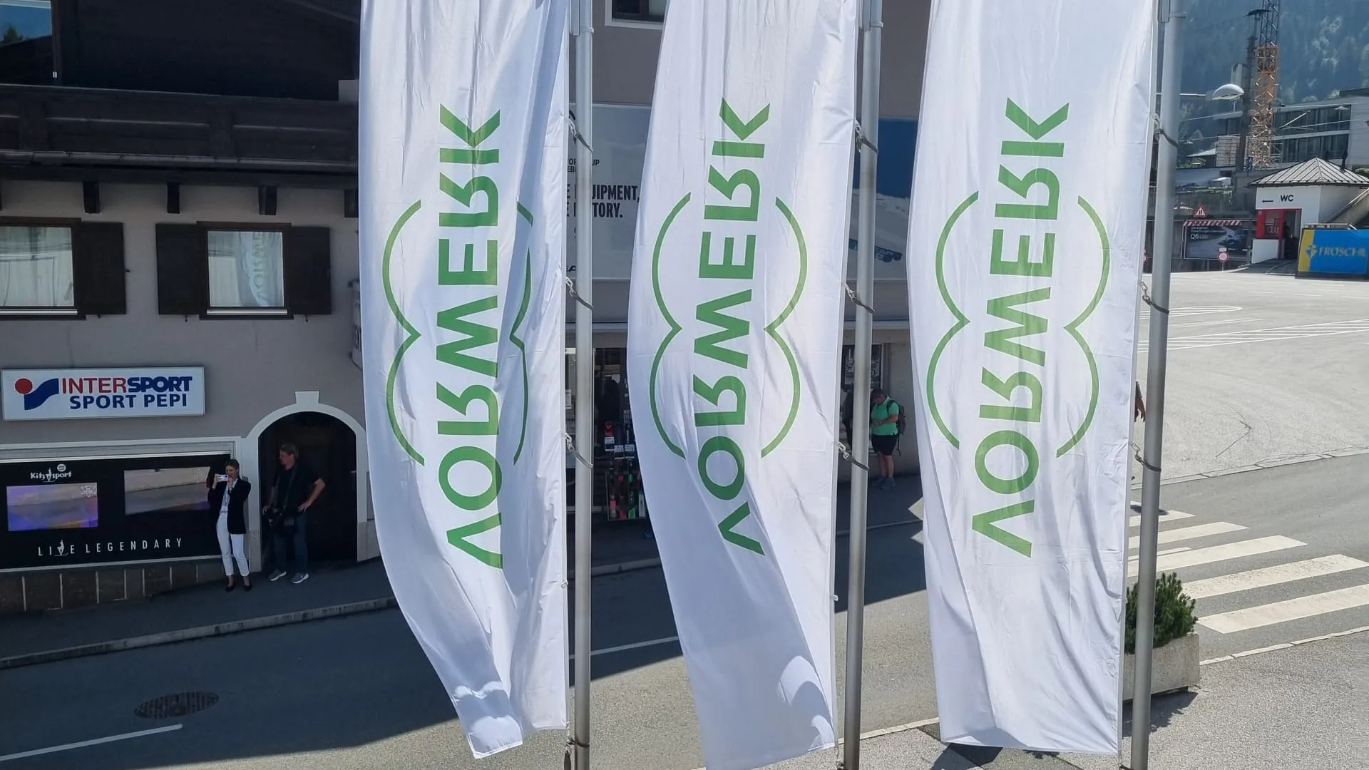 Drei Flaggen mit dem Schriftzug 'Löwenmek' in der Stadt.